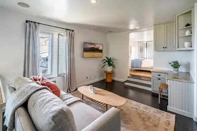 a living room with a couch and a bed at Ocean Breeze Abode and Bungalow by Paradise Retreats in Summerland