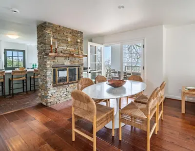 a dining room with a table and chairs and a fireplace at Ocean Breeze Abode and Bungalow by Paradise Retreats in Summerland