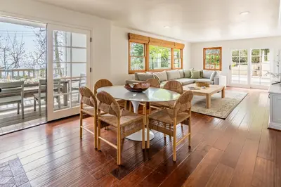 a living room with a table and chairs at Ocean Breeze Abode and Bungalow by Paradise Retreats in Summerland