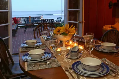 a table with plates and glasses on a table with a view at Rincon Retreat by Paradise Retreats in Carpinteria