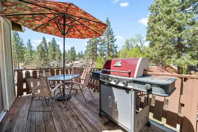 a patio with a grill and a table on a deck at Modern Lake Cabin for Family, Friends and Pets! in Big Bear Lake