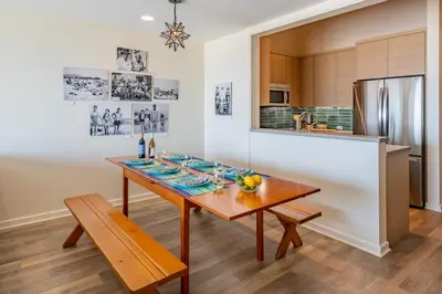 a dining room with a table and a kitchen at Seahorse Cottage by Paradise Retreats in Carpinteria