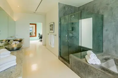 a bathroom with a glass shower and a sink at Seascape by Paradise Retreats in Carpinteria