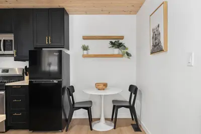 a kitchen with a small table and a black refrigerator at Newly Renovated Villa 6 Beds Fenced-in Backyard in Big Bear Lake