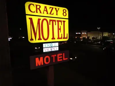 a sign for a crazy motel at night at Crzy 8 Motel in Orange