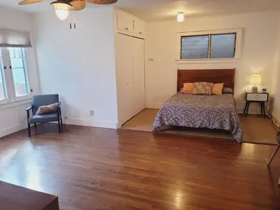 a bedroom with a bed and a chair in it at Spacious Studio Six in Hollywood! in Los Angeles