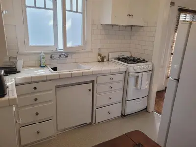 a white kitchen with a stove and a sink at Spacious Studio Six in Hollywood! in Los Angeles