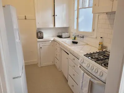 a white kitchen with a stove and a sink at Spacious Studio Six in Hollywood! in Los Angeles