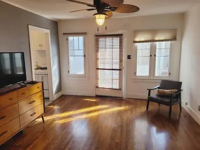 an empty living room with a dresser and a chair at Spacious Studio Six in Hollywood! in Los Angeles