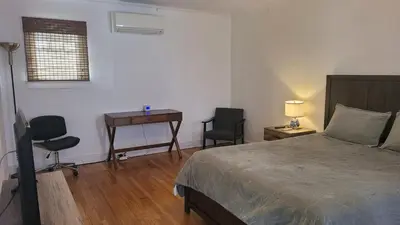 a bedroom with a bed and a desk with two chairs at Amazing Hollywood Bungalow Three! in Los Angeles