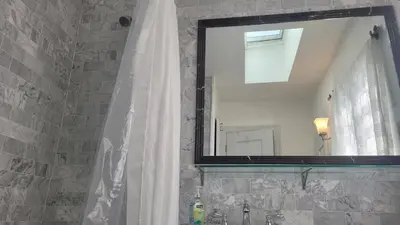 a bathroom with a shower curtain and a mirror at Amazing Hollywood Bungalow Three! in Los Angeles