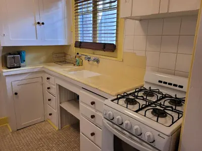 a white kitchen with a stove and a sink at Beautiful Bungalow Five in Hollywood! in Los Angeles