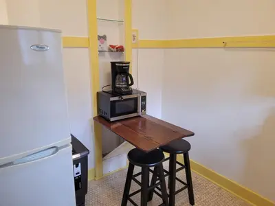 a kitchen with a table with a microwave and two stools at Beautiful Bungalow Five in Hollywood! in Los Angeles