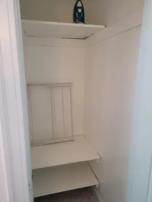 a small closet with white shelves and a clock on the ceiling at Beautiful Bungalow Five in Hollywood! in Los Angeles