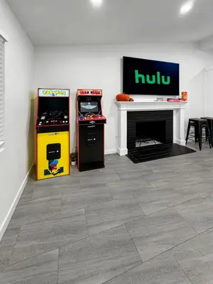 a room with two arcade games and a fireplace at Modern Home for Large Families by Disney & Knotts in Anaheim