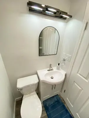 a bathroom with a toilet and a sink and a mirror at HubCityJewel in Compton