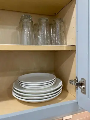 a stack of plates and glass jars in a cabinet at HubCityJewel in Compton