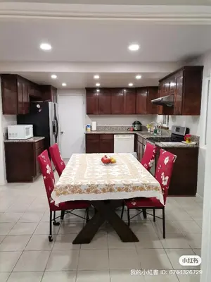 a kitchen with a table with red chairs and a kitchen with a refrigerator at In a quiet neighborhood near the Main Street-Room C in Rowland Heights