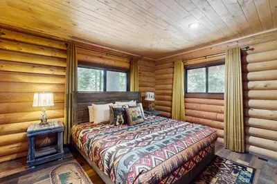 a bedroom with a bed in a log cabin at Sugar Pine Retreat in Twin Peaks