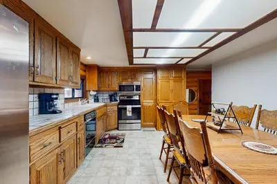 a kitchen with wooden cabinets and a table with chairs at Sugar Pine Retreat in Twin Peaks