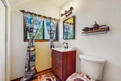 a bathroom with a toilet and a sink and a window at Sugar Pine Retreat in Twin Peaks
