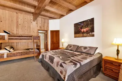 a bedroom with a bed in a room with wooden walls at Bear Lake Lodge #2547 in Big Bear Lake