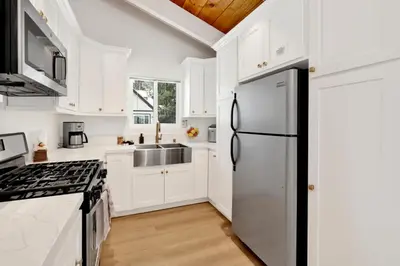 a kitchen with white cabinets and a refrigerator at Suenos Azules #2517 in Fawnskin