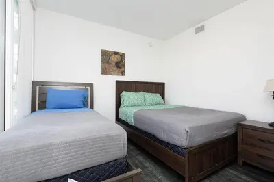 two beds sitting next to each other in a bedroom at Stylish 3BR High-Rise with Pool, Hot Tub & Rooftop Views in Los Angeles