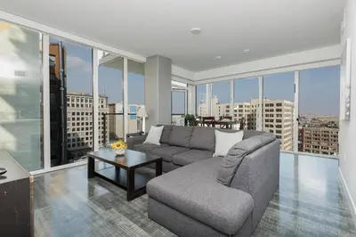 a living room with a couch and a table at Stylish 3BR High-Rise with Pool, Hot Tub & Rooftop Views in Los Angeles