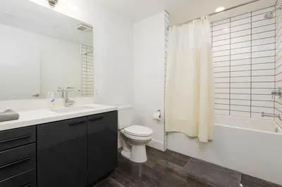 a bathroom with a sink and a toilet and a shower at Stylish 3BR High-Rise with Pool, Hot Tub & Rooftop Views in Los Angeles