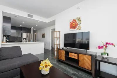 a living room with a couch and a tv at Stylish 3BR High-Rise with Pool, Hot Tub & Rooftop Views in Los Angeles