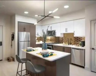 a kitchen with white cabinets and a island with chairs at Cozy 2 Bedroom Apartment Near Disneyland and Anaheim Convention Center in Orange