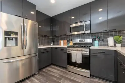 a kitchen with stainless steel appliances and gray cabinets at Snazzy 3 Bedroom High Rise with Pool, Hot Tub and Rooftop Deck in Los Angeles