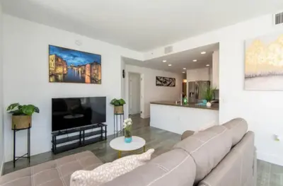 a living room with a couch and a tv at Snazzy 3 Bedroom High Rise with Pool, Hot Tub and Rooftop Deck in Los Angeles