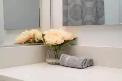 a vase of pink flowers sitting on a bathroom counter at Snazzy 3 Bedroom High Rise with Pool, Hot Tub and Rooftop Deck in Los Angeles