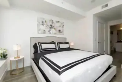 a white bedroom with a black and white bed at Beautiful 3 Bedroom High Rise with Pool, Hot Tub and Rooftop Views in Los Angeles