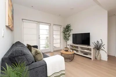 a living room with a couch and a flat screen tv at Walk to Santa Monica Beach, Pier, Boardwalk and Venice in Los Angeles
