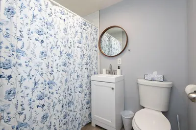 a bathroom with a toilet and a blue and white shower curtain at Spacious 3 Bedroom 2 Bathroom Apartment with Free Onsite Parking in Los Angeles