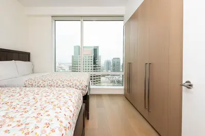a bedroom with two beds and a large window at Cozy 3BR High Rise with Pool with great views in Los Angeles