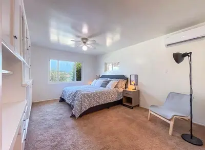 a bedroom with a bed and a lamp and a chair at Hillside-This is a House with 5 master suite in Riverside