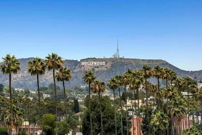 a view of the hollywood sign from palm trees at Snazzy 2 Bedroom Pad with Rooftop Pool and Hollywood Sign View in Los Angeles