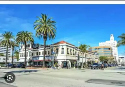 a city street with palm trees and a building at Hosp Walk to Santa Monica Beach Pier in Los Angeles