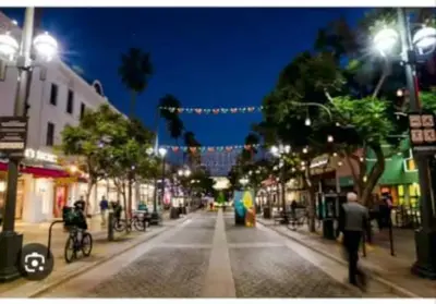 a city street at night with people walking down the street at Hosp Walk to Santa Monica Beach Pier in Los Angeles