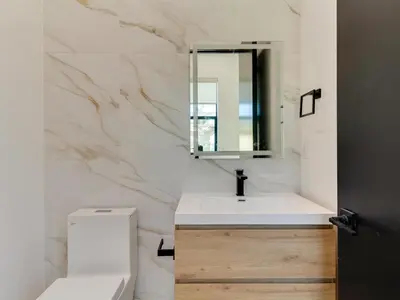 a bathroom with a sink and a toilet and a mirror at Modern Luxe Retreat 3-Bedroom #3 in Los Angeles