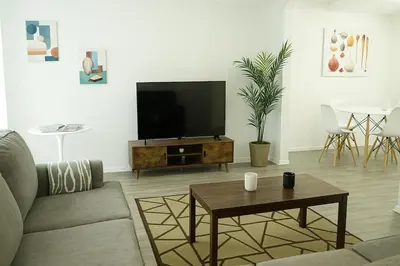 a living room with a flat screen tv on a table at Spacious 2BR Townhouse - 3 Queens - Sleeps 8 in Redondo Beach