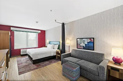 a hotel room with a bed and a couch at Home2 Suites By Hilton Riverside Downtown in Riverside