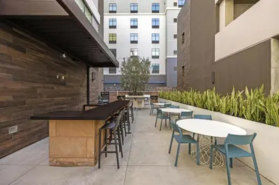 a patio with tables and chairs and a building at Home2 Suites By Hilton Riverside Downtown in Riverside