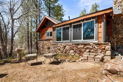 a log cabin with a large window on it at StoneHauz was built in 1926! It's a REAL CABIN! in Big Bear Lake