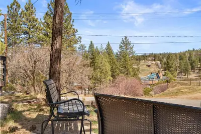 two chairs sitting on a balcony with a tree at StoneHauz was built in 1926! It's a REAL CABIN! in Big Bear Lake