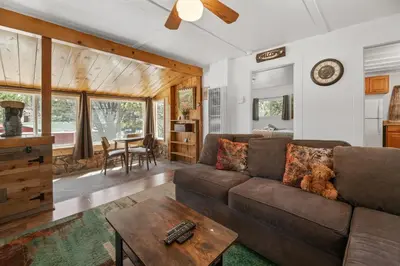 a living room with a couch and a table at StoneHauz was built in 1926! It's a REAL CABIN! in Big Bear Lake